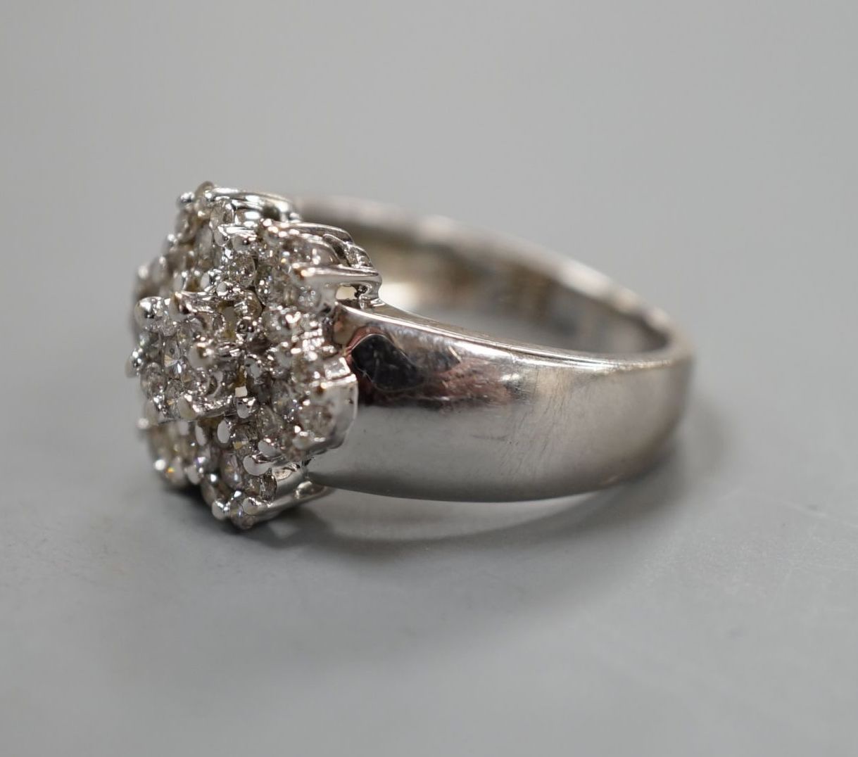 A modern 14k white metal and multiple diamond cluster set flower head ring, size M, gross weight 8.7 grams.